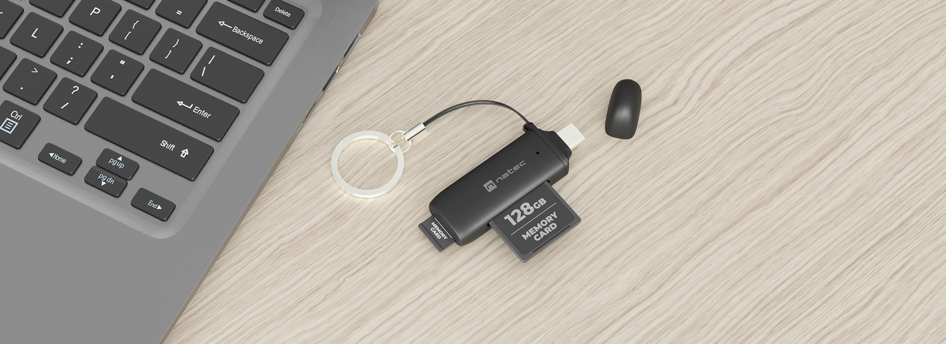 Czarny czytnik kart ze złączem USB, obsługujący karty SD i micro SD, umieszczony obok laptopa