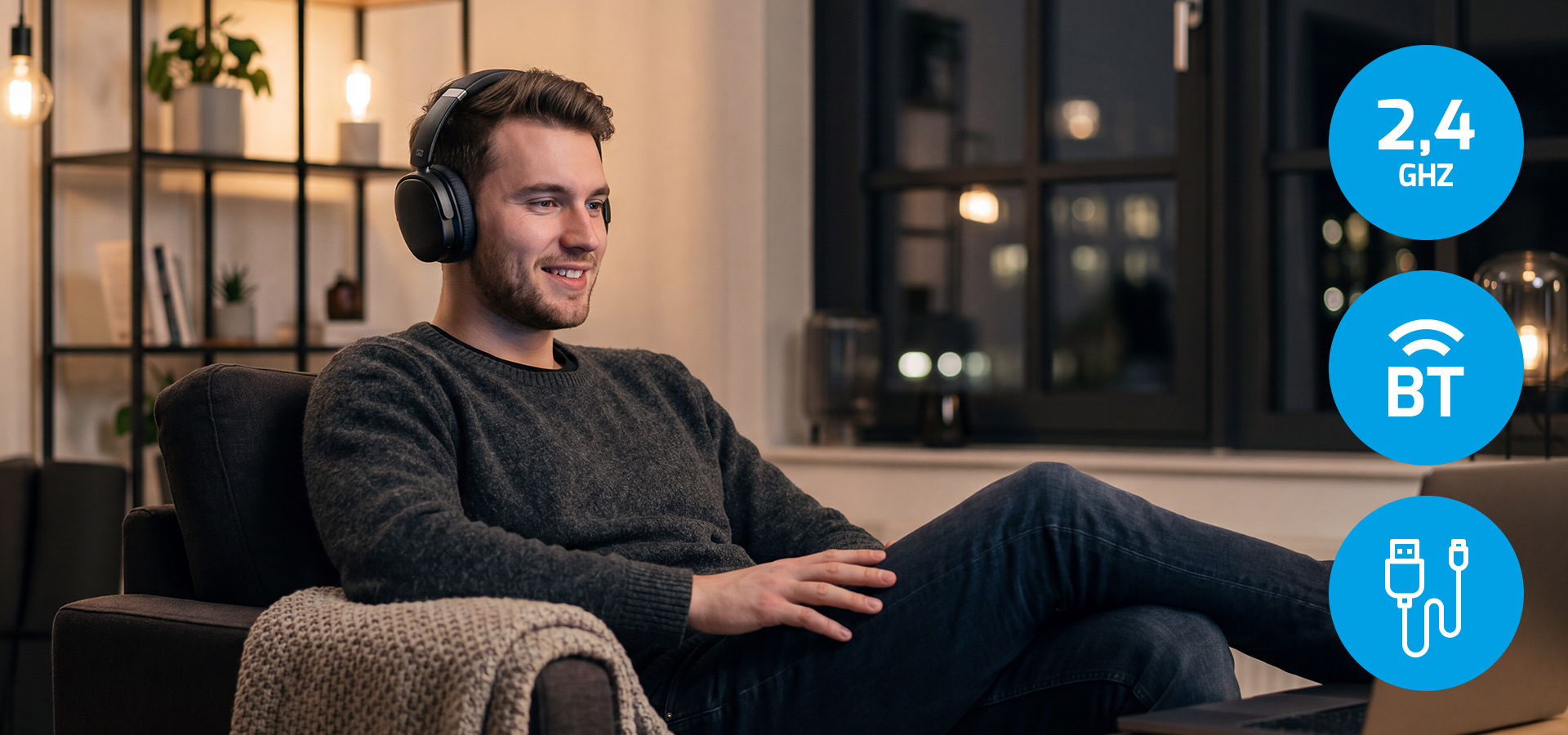 Man wearing headphones while sitting comfortably on a couch in a cozy room.