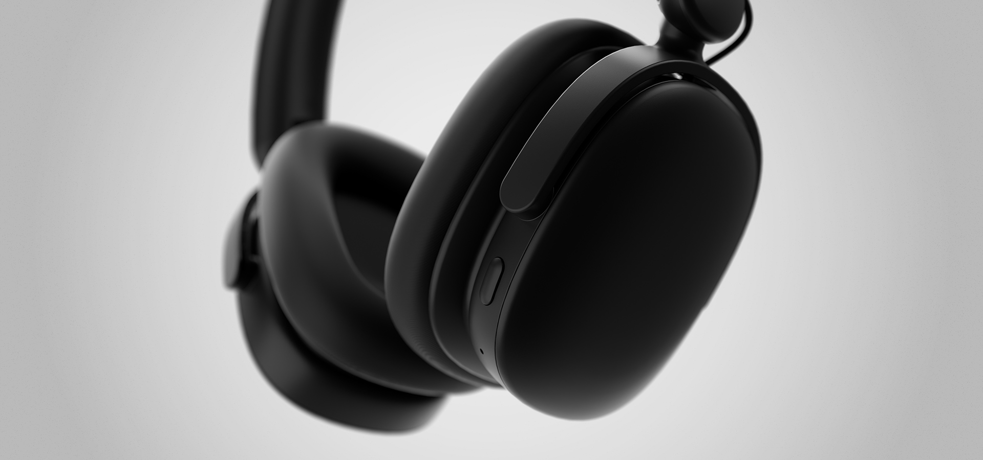 Black over-ear headphones with a smooth design and control buttons on the side.