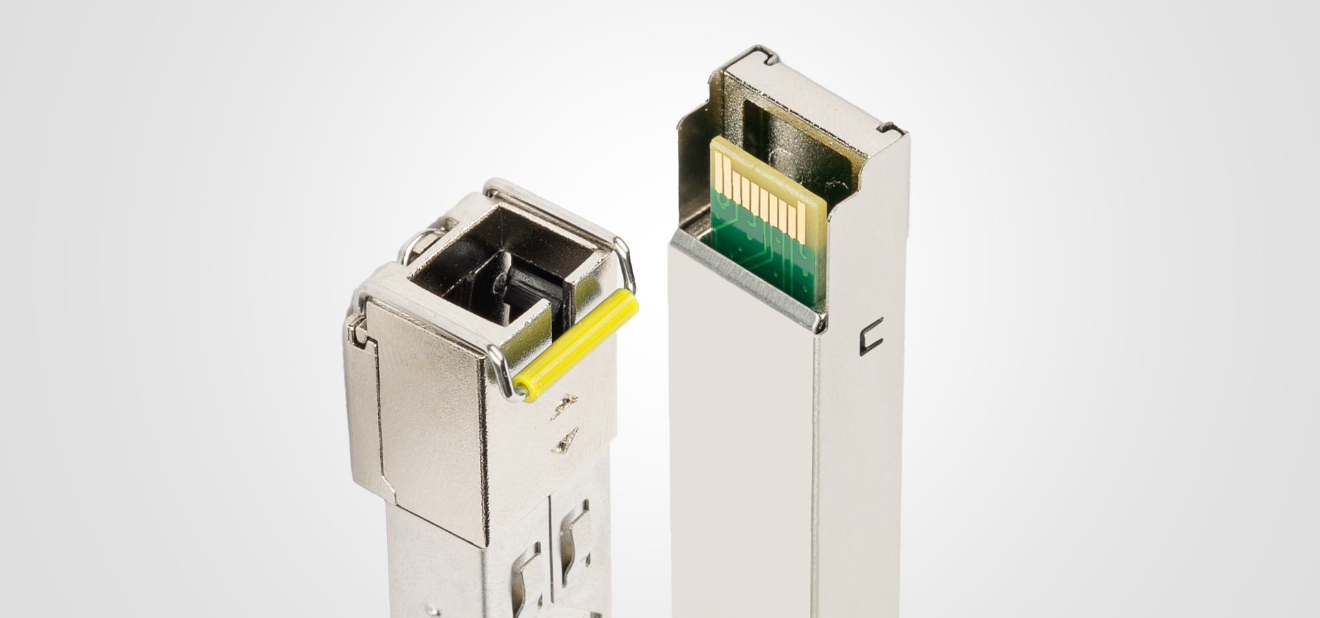 Two metallic connectors with green and yellow parts on a light background.