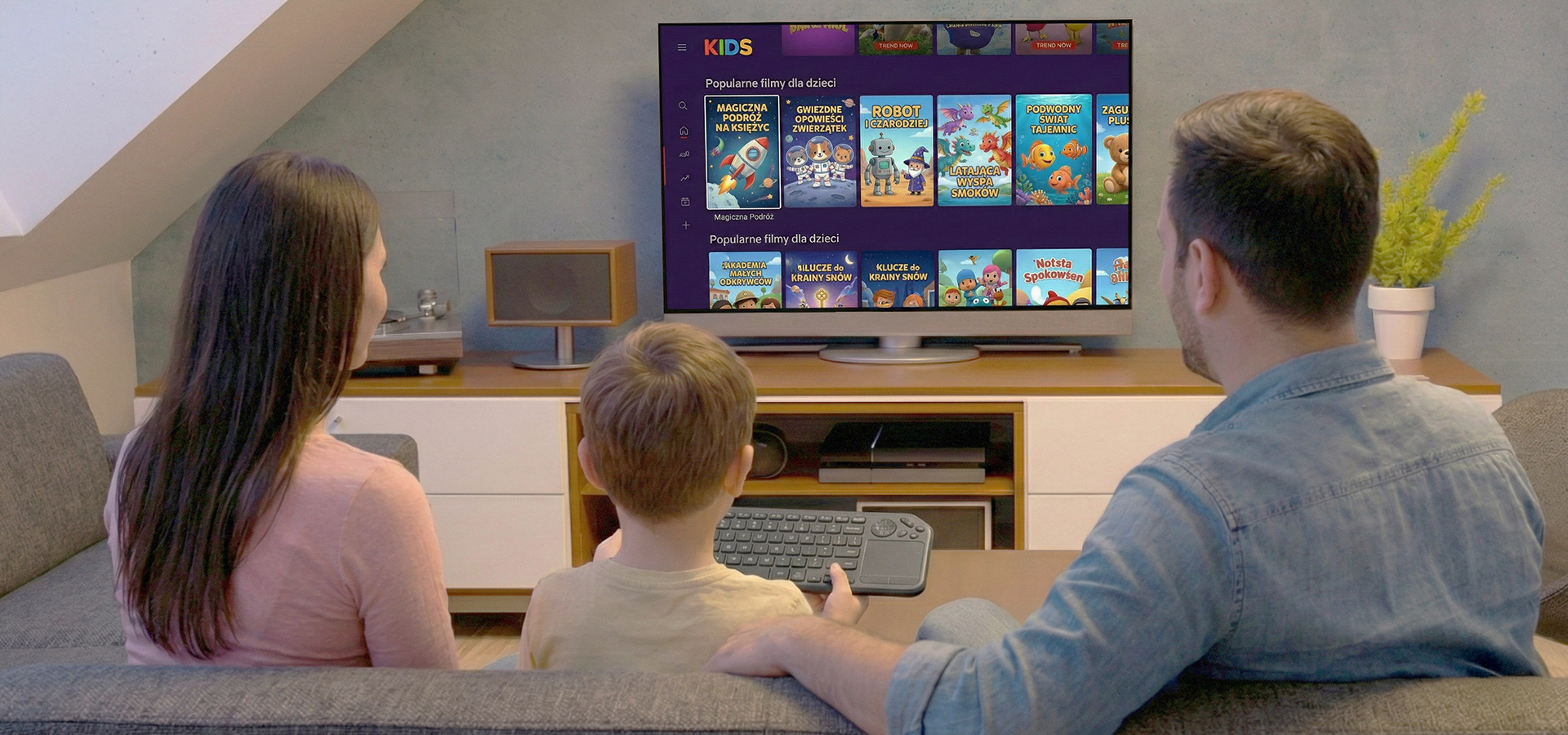 Rodzina siedząca na kanapie, oglądająca telewizor z opcjami filmów dla dzieci.
