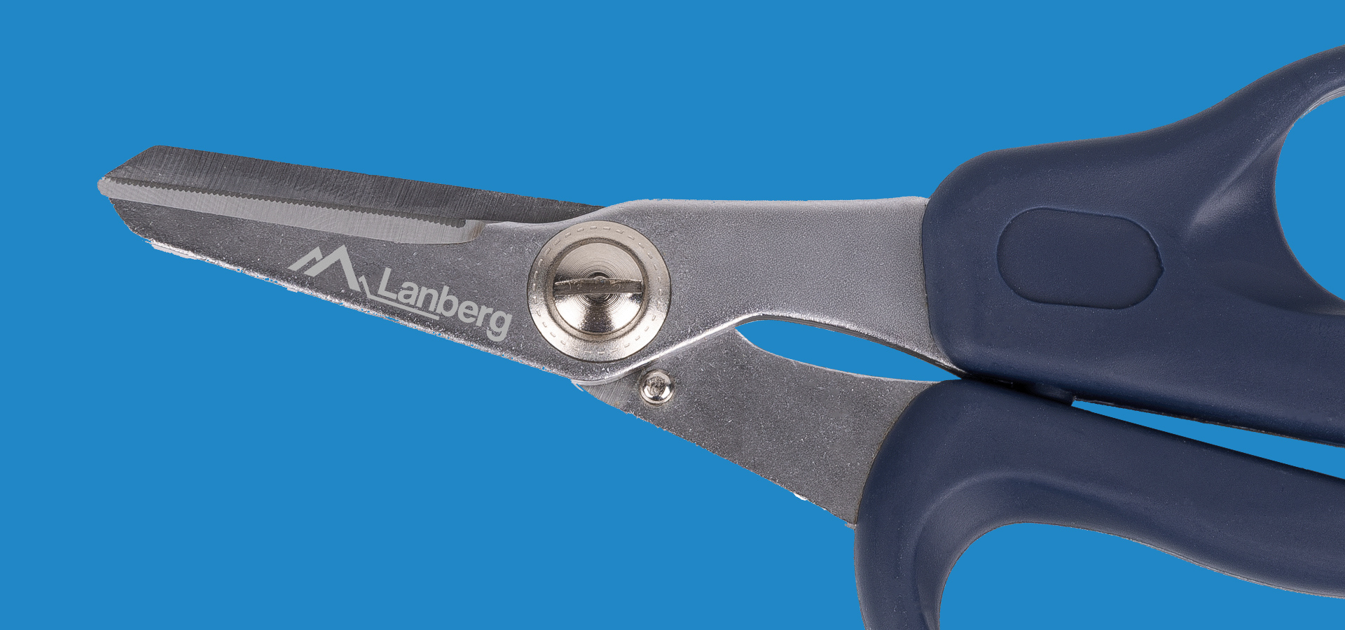 Nożyce ze stalowymi ostrzami i niebieską rączką na niebieskim tle.