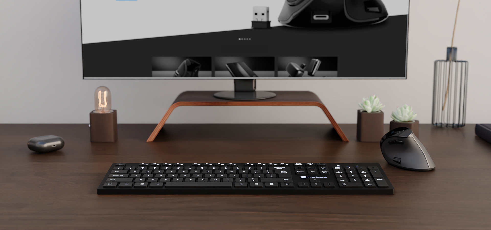 Miejsce pracy z klawiaturą, myszką i monitorem na drewnianym biurku z dekoracjami.