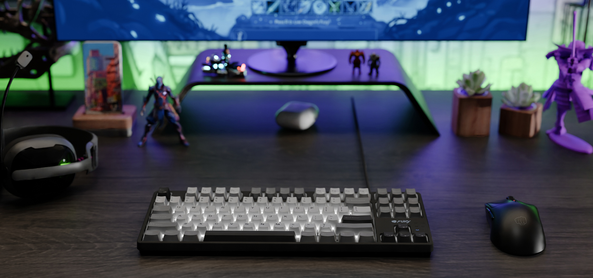 Klawiatura z przeźroczystymi i ciemnymi klawiszami na biurku obok myszy i figurek do gry.