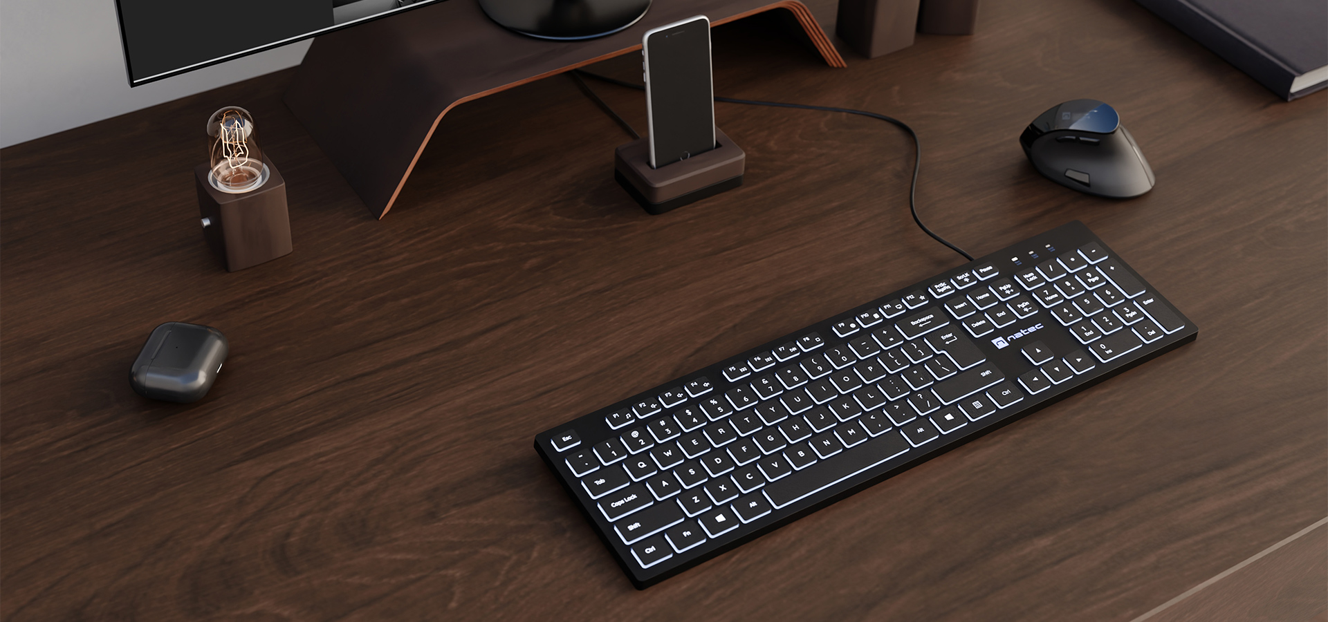 Czarna klawiatura z białym podświetleniem, mysz komputerowa i akcesoria na drewnianym biurku