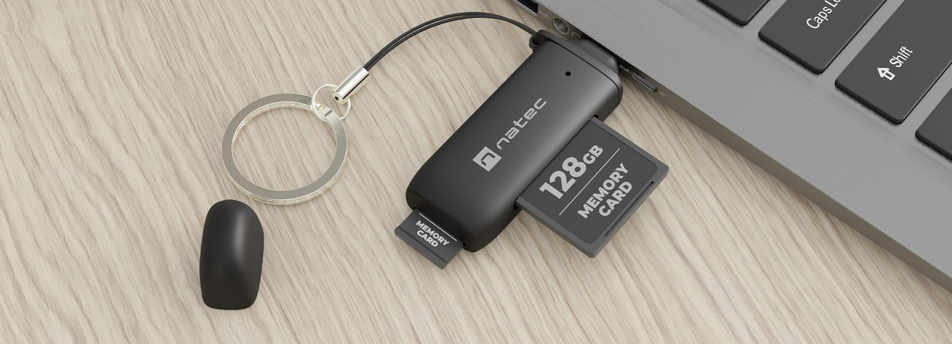 Kompaktowy czytnik kart z włożoną kartą SD i microSD, podłączony za pomocą breloka do laptopa
