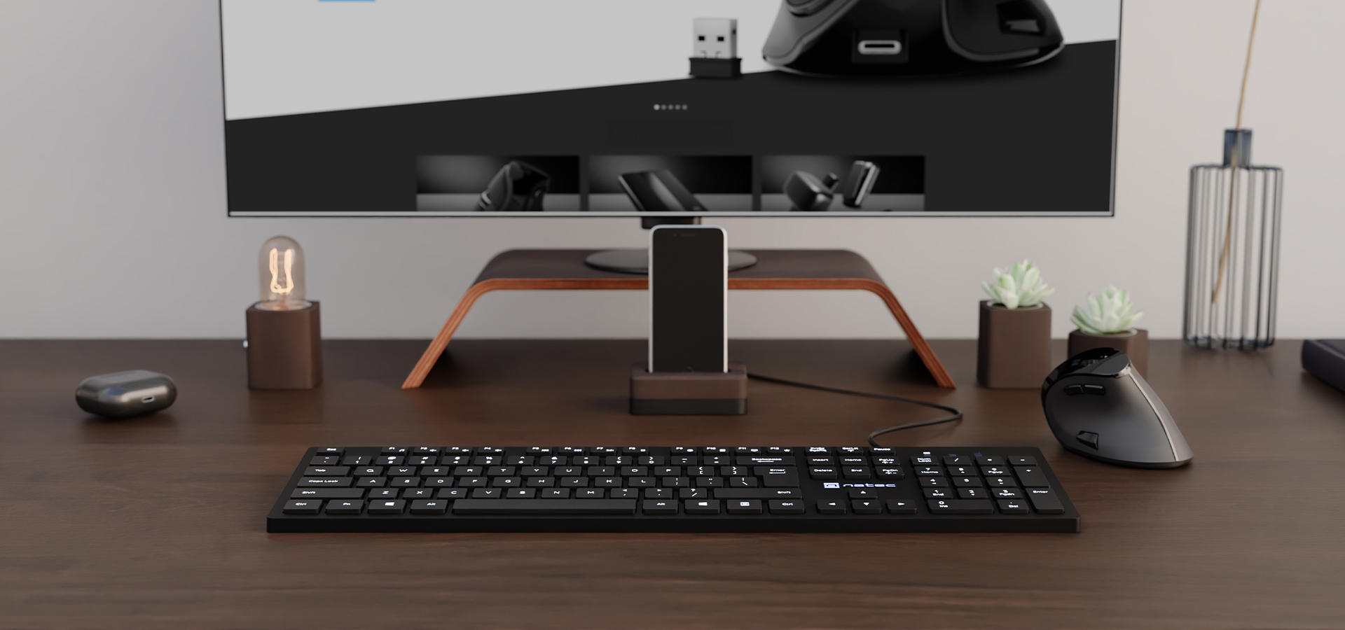 Smukła czarna klawiatura multimedialna na drewnianym biurku z monitorem i akcesoriami
